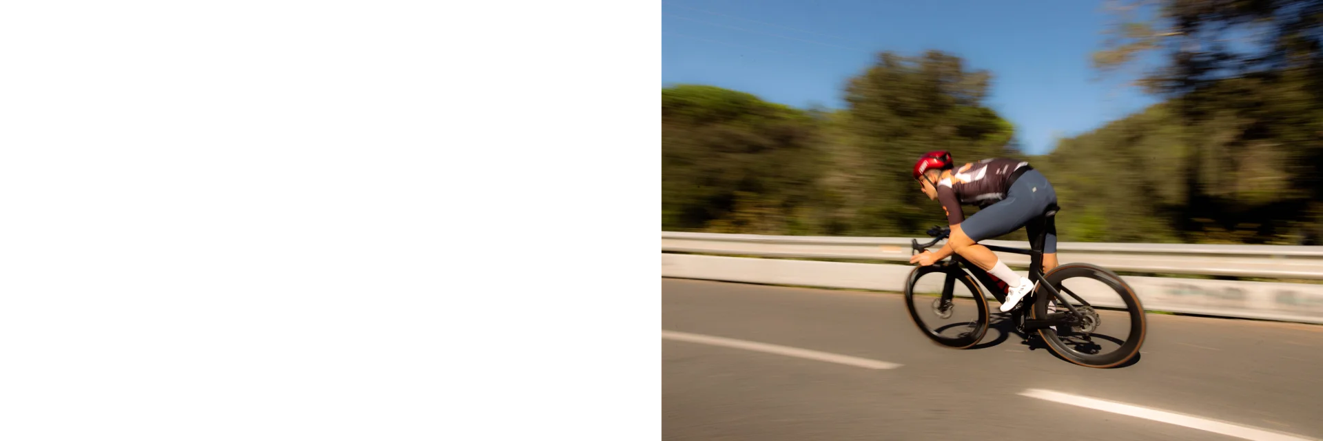 Tymon cycling at speed on a sunlit road
